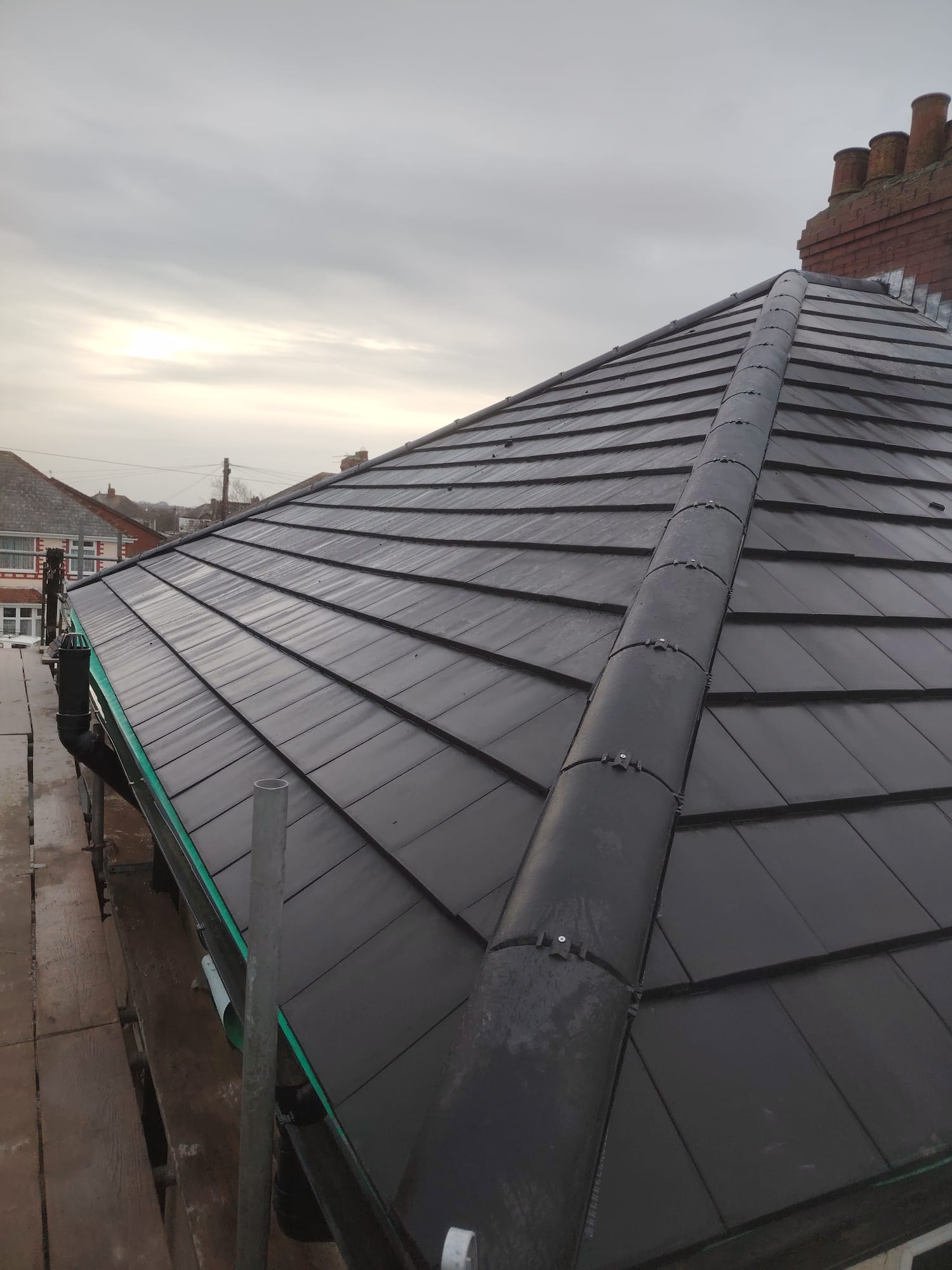 Newly completed dark grey tiled roof after a full replacement in Blackpool